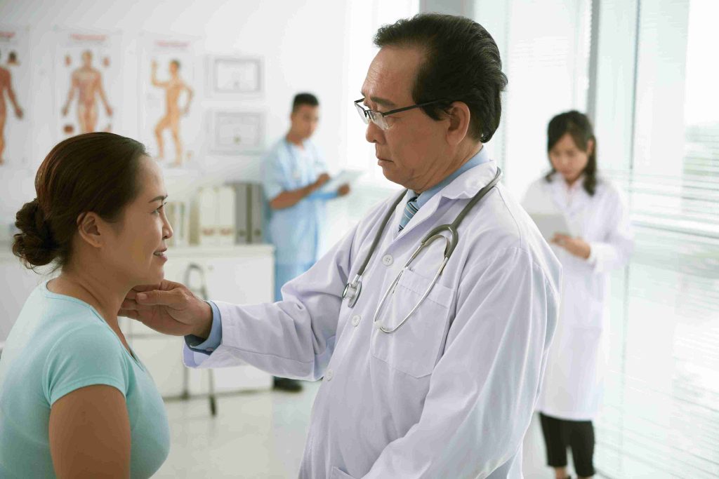 elderly doctor examining a female patient