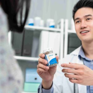 young doctor showing patient a medication