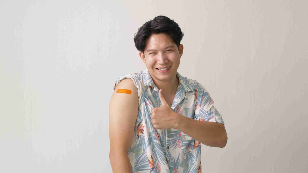 asian male giving a thumbs up after flu vaccine