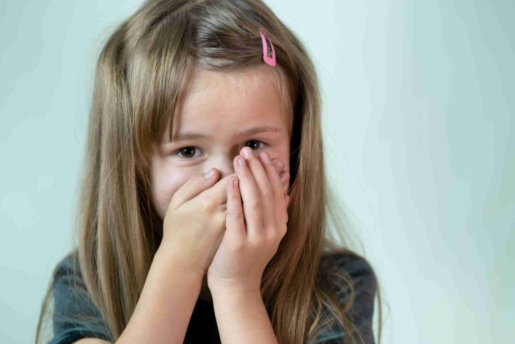 little girl with her hands on her mouth