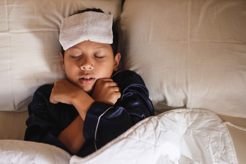 young male child in bed with fever