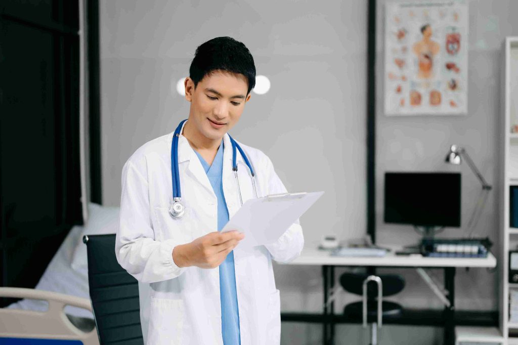 Young doctor looking at something in his clinic.
