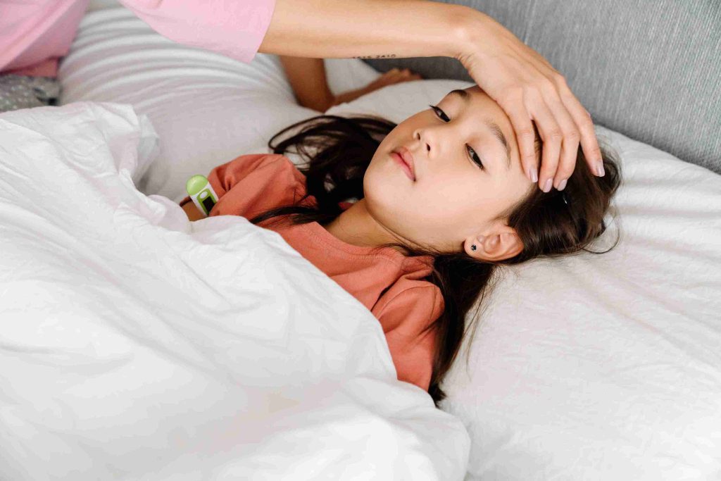 Asian child lying in bed with fever.