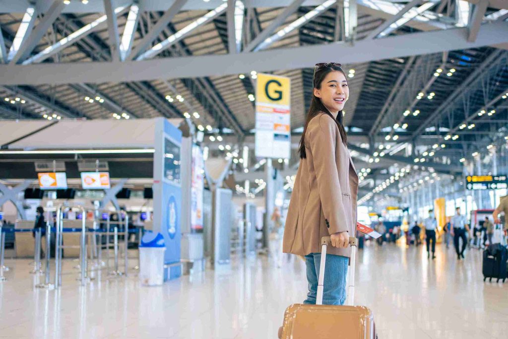 Young asian with her luggage in the airport.