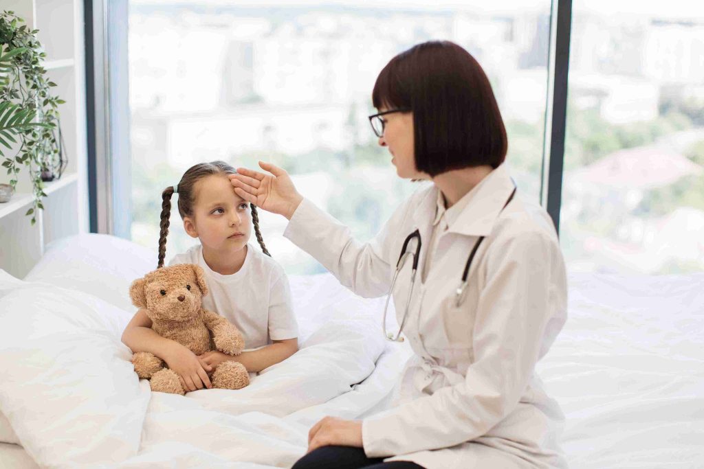 Doctor checking a little girl's temperature.
