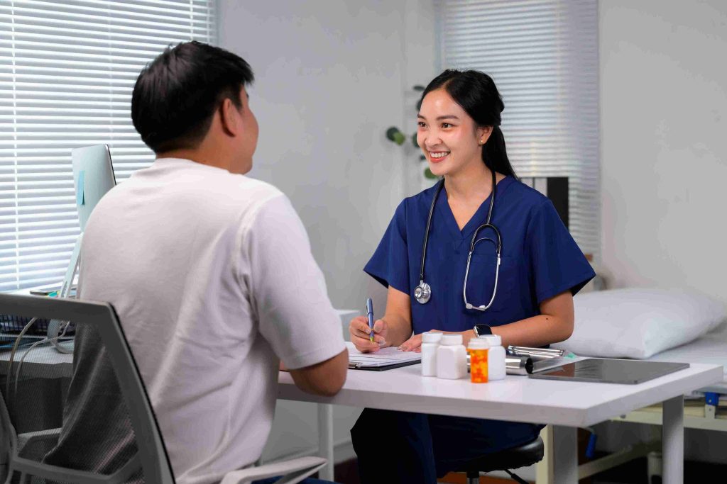 Young doctor smiling and speaking with a patient.