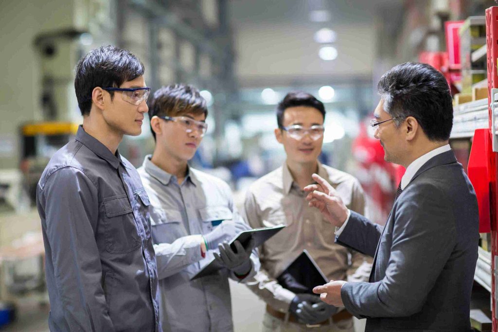 Asian businessmen and engineers talking in the factory.